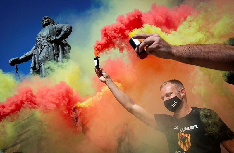 Un hombre con bengalas de humo de colores