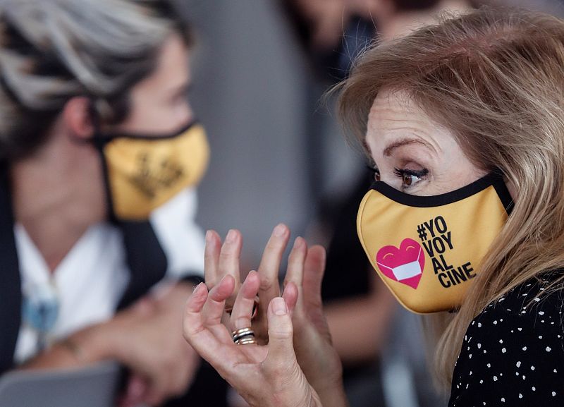 Una mujer lleva una mascarilla con el lema "Yo voy al cine"