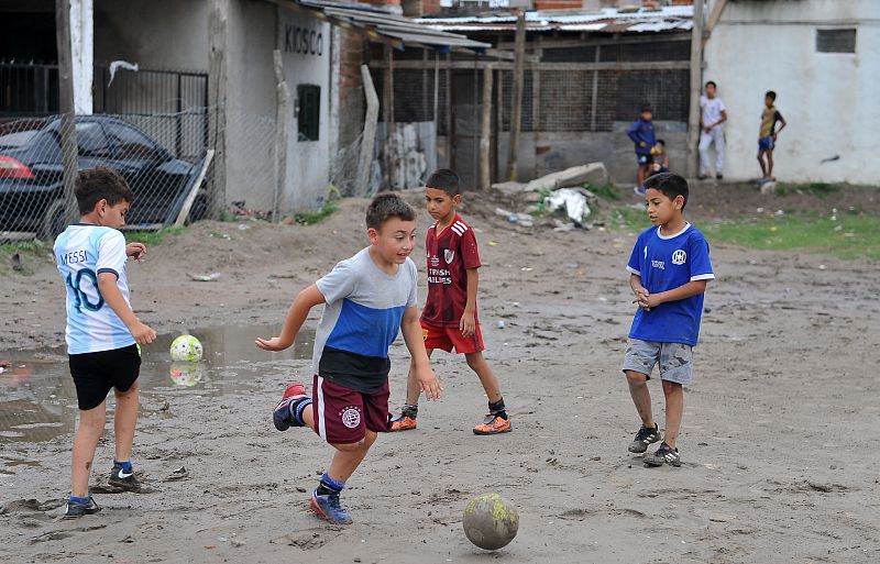 Un grupo de niños juega en la cancha embarrada del Club Atlético Estrella Roja, el mismo lugar donde empezó a hacerlo Maradona en Villa Fiorito, en la provincia de Buenos Aires.