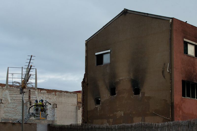 Los bomberos realizan su trabajo para intentar acabar de sofocar el incendio, ya controlado.