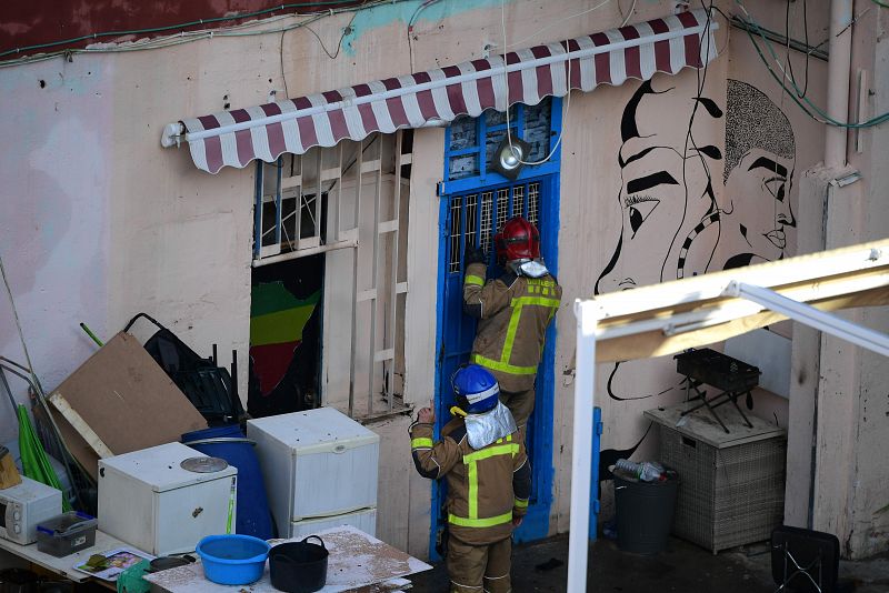 Los bomberos inspeccionan la nave incendiada en Badalona