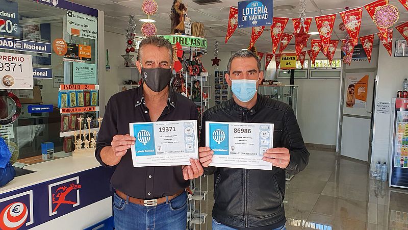 Jesús Sánchez padre e hijo posan junto a los dos quintos premios de Navidad vendidos en Roquetas