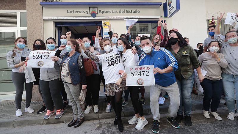 Un grupo de personas celebra el tercer premio frente a la adminitración número 2 de Barbate