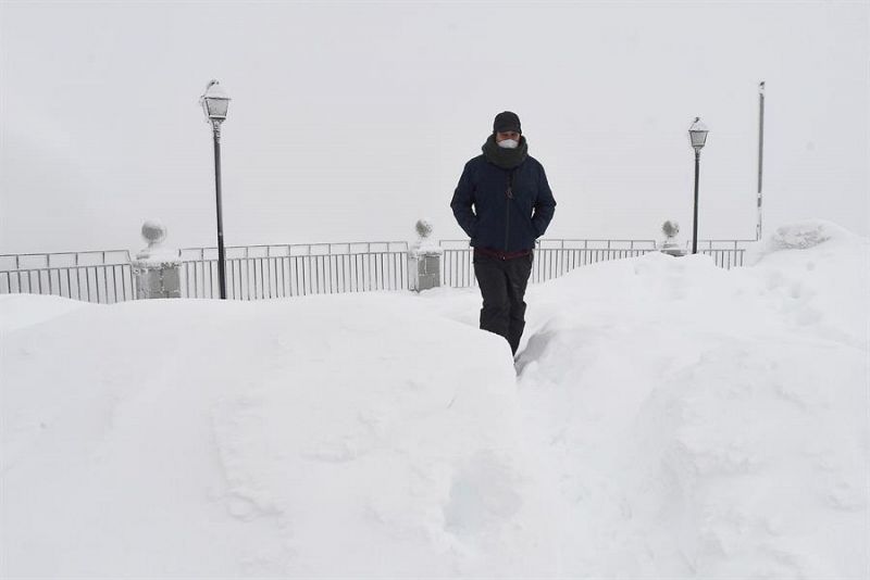 Un hombre pasea entre la nieve caída en el Alto del Puerto de Pajares (León).