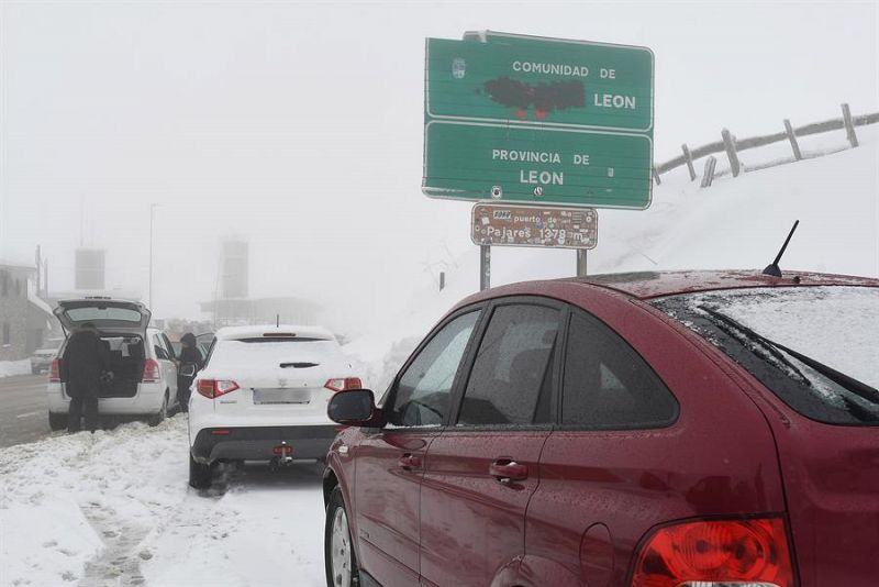 Vista de los coches en el Alto del Puerto de Pajares (León) este domingo, que está cerrado para vehículos pesados mientras que los turismo pueden circular con cadenas o neumáticos especiales de invierno por culpa del temporal de nieve y frío.