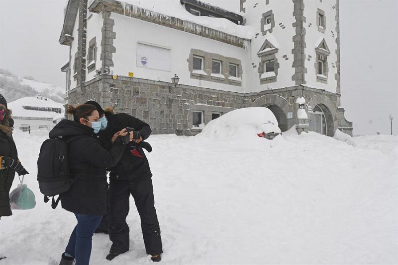 Varias personas disfrutan de la nieve en el Alto del Puerto de Pajares (León) este domingo.