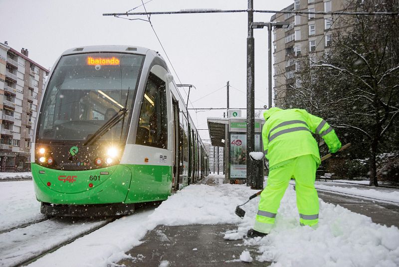 Un operario limpia los andenes del tranvía en Vitoria este sábado. La ciudad amaneció cubierta de nieve por el temporal de frio que azota el norte de la península.