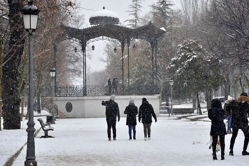 Varias personas caminan entre la nieve por el Parque Lineal de Albacete en una jornada marcada por las bajas temperaturas en toda la península.