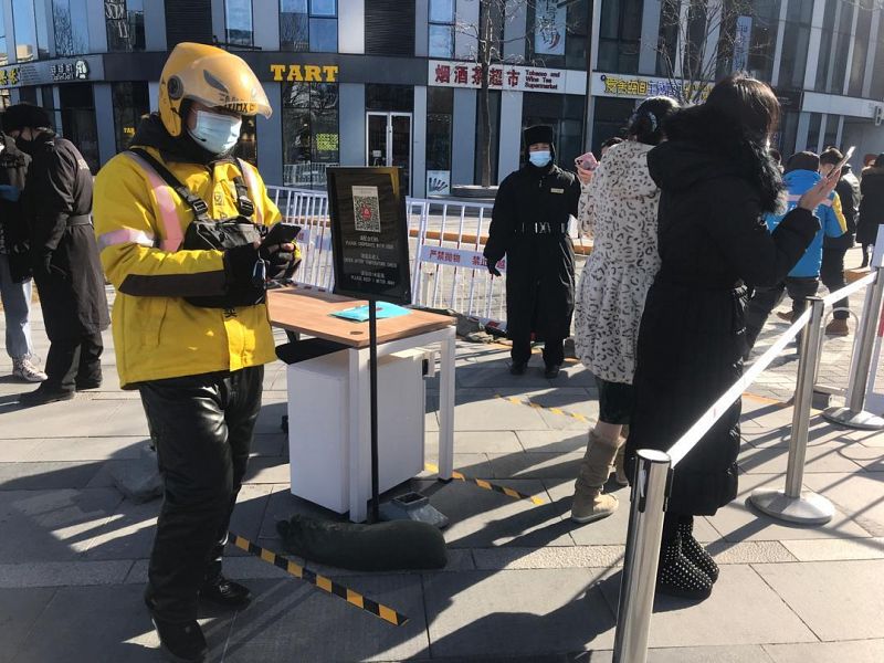 Un vigilante comprueba el estado de salud de los usuarios a través de una aplicación móvil en un barrio de Pekín.