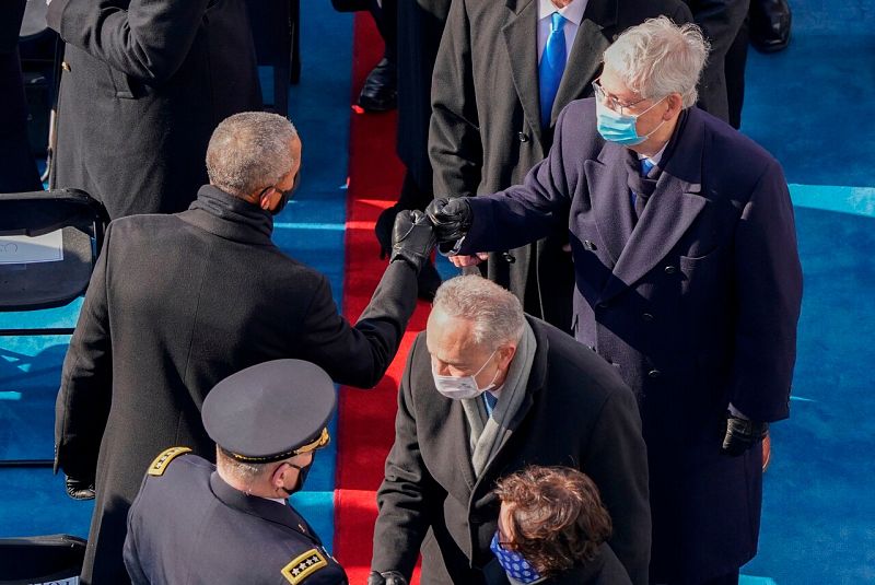 El expresidente demócrata Barack Obama (I) saluda al senador republicano Mitch McConnell (D)