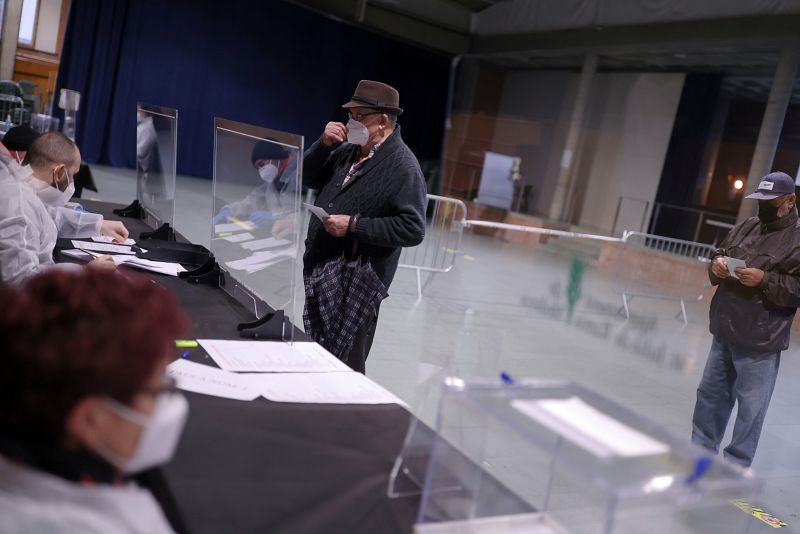 Un hombre vota con mascarilla en Girona