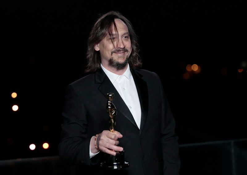 El compositor francés Nicolas Becker sonríe mientras sostiene su estatuilla del Oscar al Mejor Sonido por 'Sound of Metal'