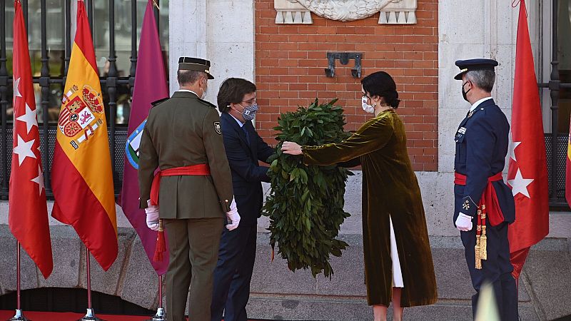 La presidenta de la Comunidad de Madrid, Isabel Díaz Ayuso, acompañada por el alcalde de Madrid José Luis Martínez-Almeida, colocan una corona delante de la placa conmemorativa a los Héroes del 2 de Mayo.