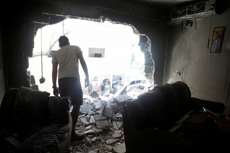 Un hombre sobre los escombros observa los daños después de que un cohete lanzado durante la noche desde la Franja de Gaza golpeara un edificio residencial en Petah Tikva, Israel.