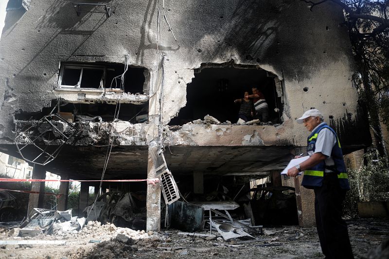 Israelíes observan los daños después de que un cohete lanzado durante la noche desde la Franja de Gaza golpeara un edificio residencial en Petah Tikva.