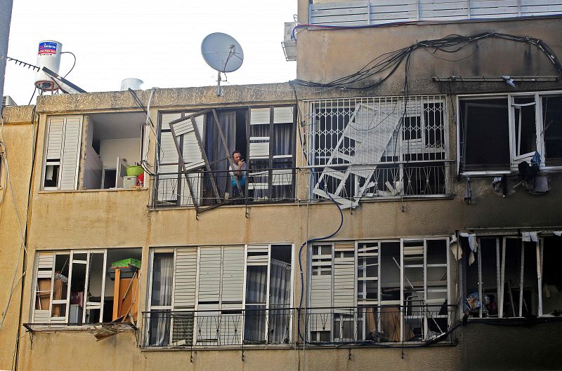 Un hombre israelí comprueba los daños en un edificio después de un ataque con cohetes desde la Franja de Gaza controlada por Hamas.