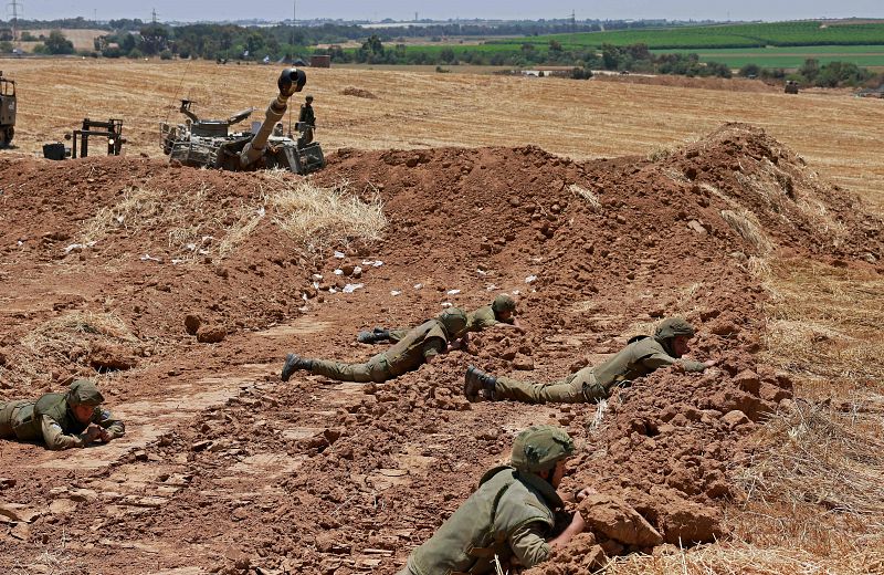 Soldados israelíes se refugian en su posición cerca de Sderot en el sur de Israel en la frontera con la Franja de Gaza controlada por Hamas durante el bombardeo.