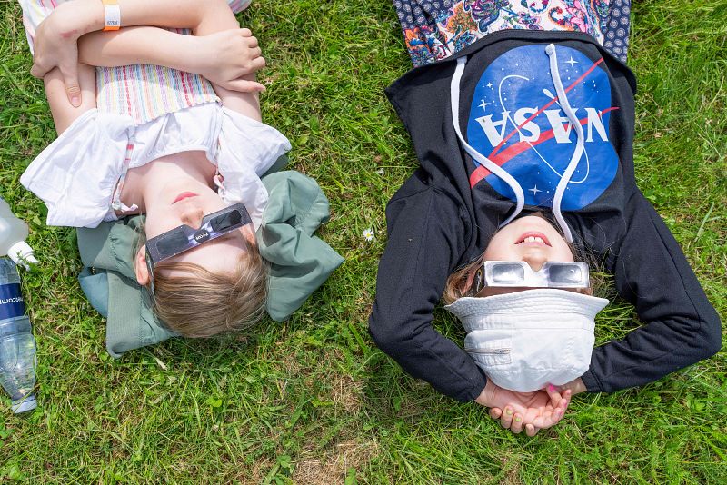 Niños, tumbados y protegidos con gafas especiales, observan el eclipse en el observatorio Brorfelde de Tollose, Dinamarca.