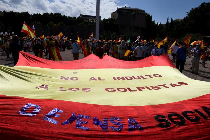 Varias personas despliegan una bandera durante la concentración convocada por la plataforma Unión 78 en la plaza de Colón