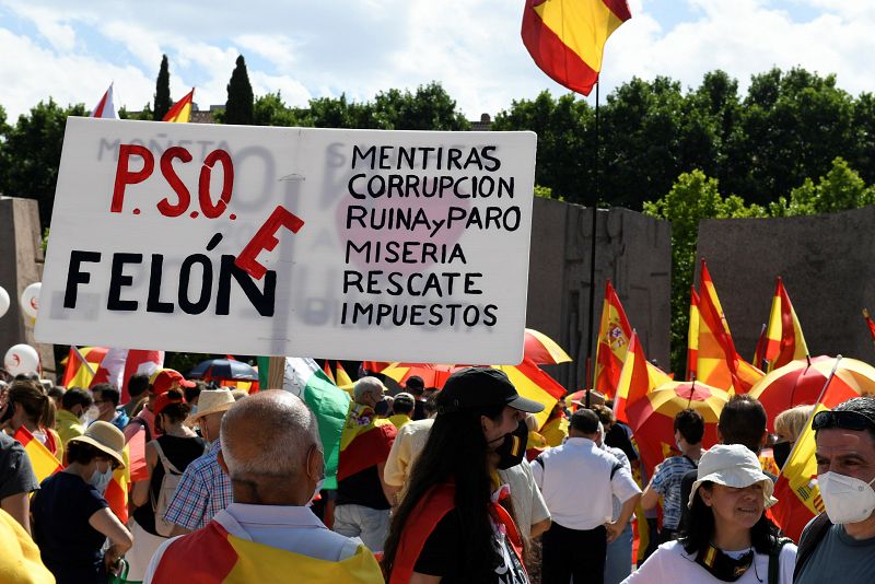 Un grupo de personas sostiene una pancarta en contra del PSOE, al que califica de "felón", en la plaza de Colón de Madrid