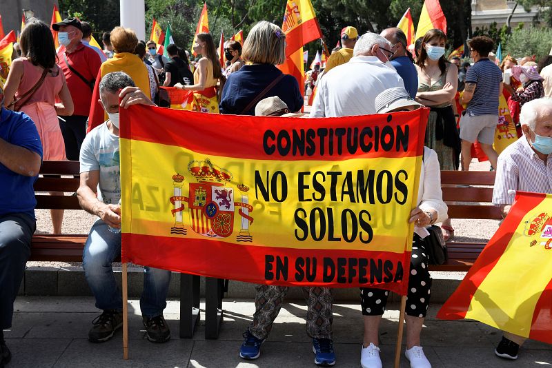 Dos manifestantes muestran una pancarta durante la concentración en la que se puede leer "Constitución, no estamos solos en su defensa"