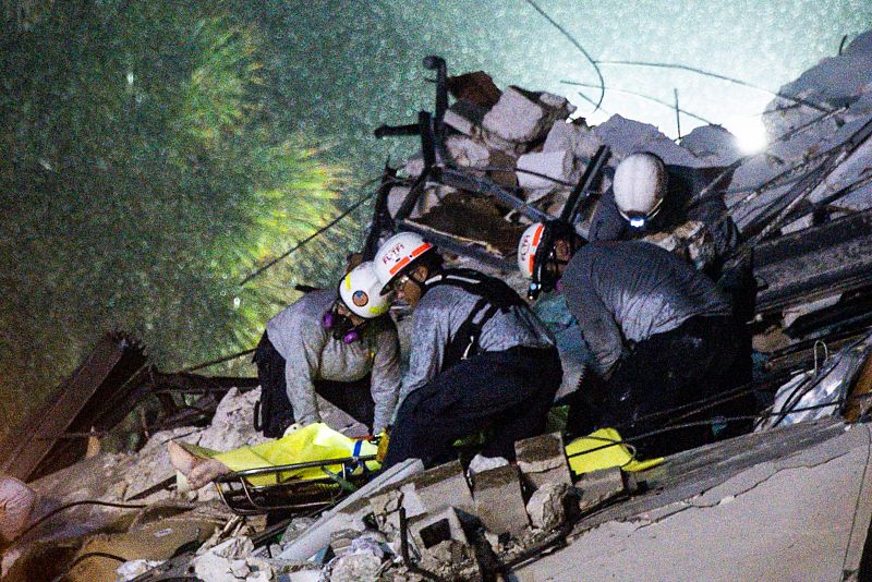 Los operarios rescatan un cuerpo de los escombros del edificio derrumbado en Miami.