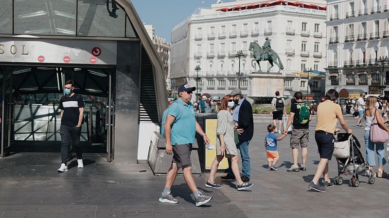 Personas con y sin mascarilla pasean por la Puerta del Sol este sábado