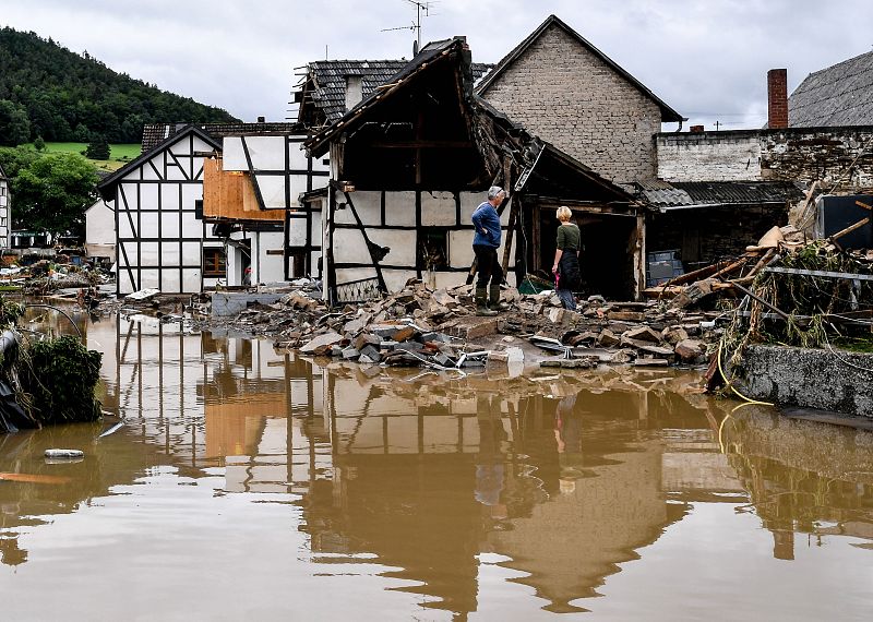 Vecinos de la zona inspeccionan una casa derrumbada después de las fuertes inundaciones del río Ahr, en Schuld, Alemania