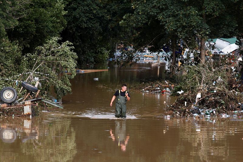 Un hombre camina por el agua en una zona afectada por las inundaciones tras las fuertes lluvias