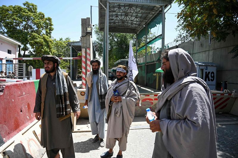 Talibanes (uno de ellos, con la bandera del Emirato Islámico de Afganistán) frente a uno de los accesos a la llamada "Zona verde", donde se encuentran las embajadas internacionales.Wakil Kohsar / AFP