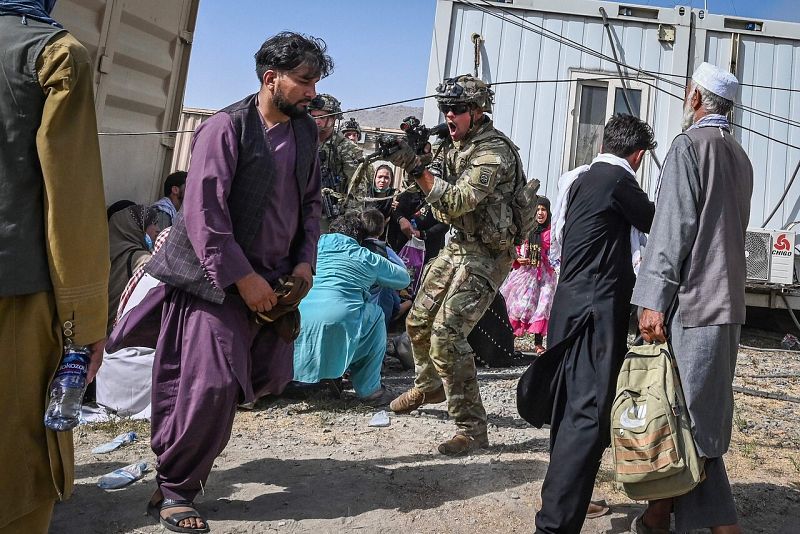 Un soldado estadounidense apunta a un afgano en el aeropuerto, donde se producen escenas de desesperación y caos. Foto: Wakil KOHSAR / AFP