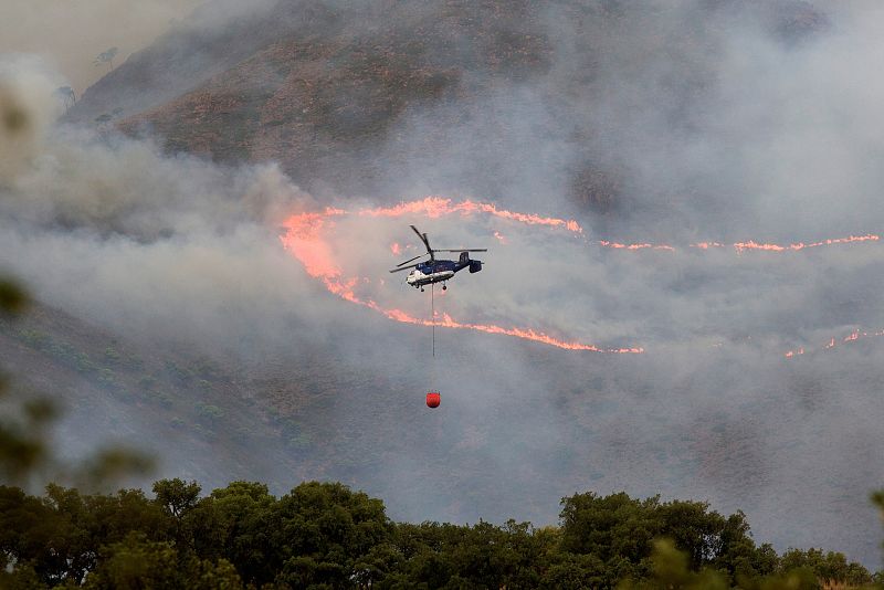 Varios medios del INFOCA, la UME y bomberos llegados de la Comunidad de Madrid, Castilla-La Mancha, Murcia y Extremadura intentan apagar el incendio de Sierra Bermeja, con la esperanza de que la lluvia prevista en la zona ayude a su extinción