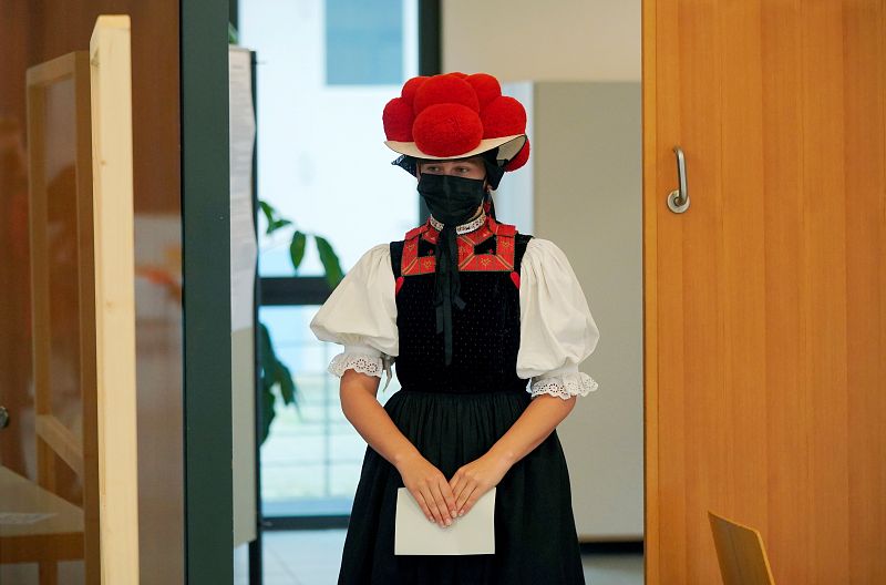 Una mujer vestida con un traje tradicional de la Selva Negra llega a un colegio electoral para emitir su voto en Gutach.