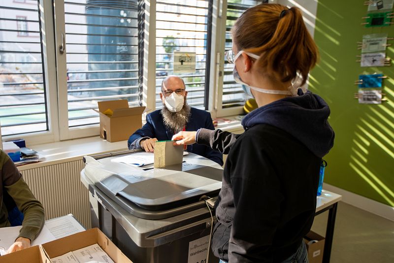 Una mujer introduce su voto para las elecciones generales alemanas en un colegio electoral en Frankfurt.