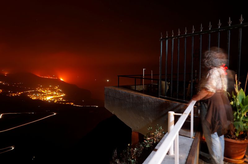 Una mujer observa la caída de la lava del mar desde un balcón en Tijarafe