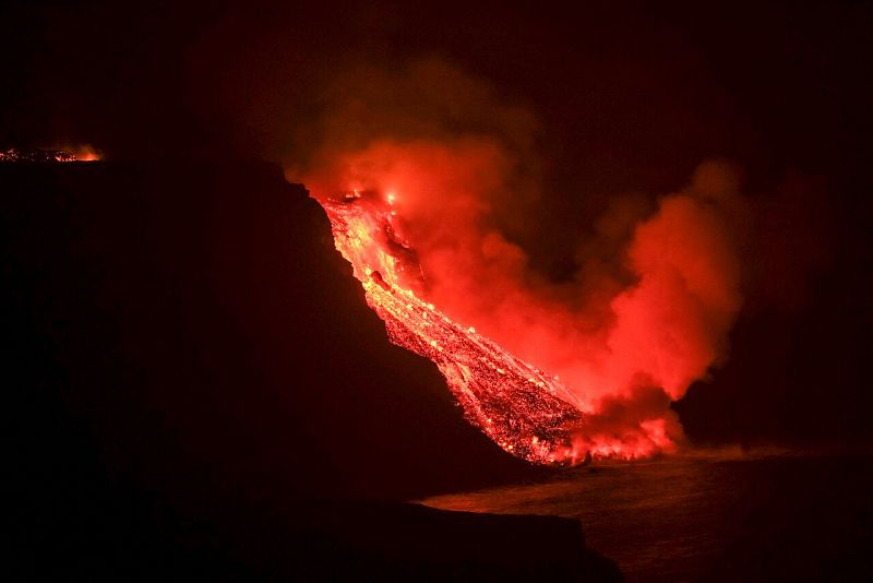 La colada de lava cae al mar en una zona de acantilados situados en las cercanías de la playa El Guirre, en Tazacorte.