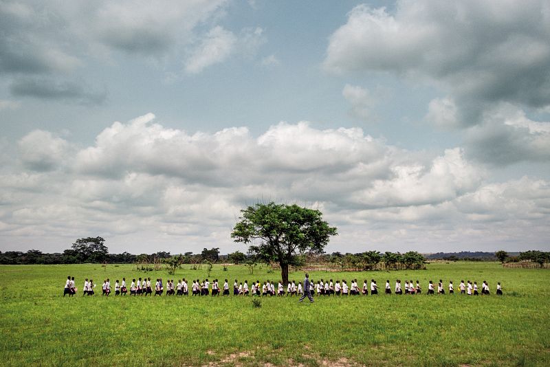 Una fila de escolares cantando en la naturaleza