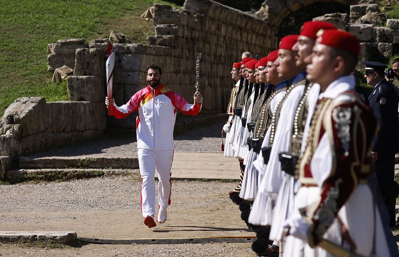 El primer portador de la llama, Ioannis Antoniou, corre con la antorcha 