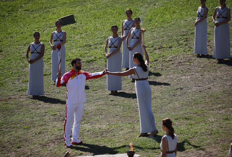 La actriz, Xanthi Georgiou, pasa la antorcha al primer portador, el esquiador, Ioannis Antoniou 