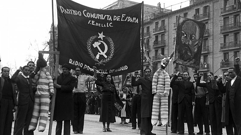 Simpatizantes comunistas portando una pancarta, peleles colgados con traje de presidiario y un retrato de Lenin durante la manifestación con motivo del Dia de los Trabajadores en Madrid, el 1 de mayo de 1936.