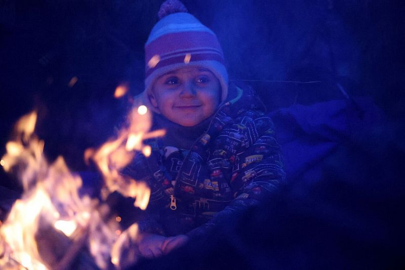 Un niño se calienta junto a una hoguera en la frontera entre Bielorrusia y Polonia. La ONU ha pedido que se atienda a los migrantes, rehenes de una crisis entre el régimen de Alexandr Lukashenko y la UE. Ramil NASIBULIN / BELTA / AFP