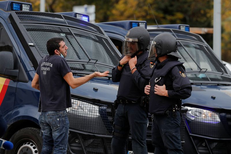 Un trabajador habla con agentes de la policía antidisturbios durante una huelga de trabajadores metalúrgicos en Puerto Real, cerca de Cádiz