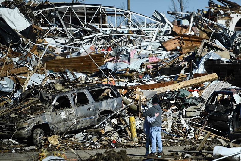 Una pareja se abraza en medio de la destrucción