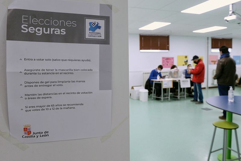 Un cartel informa de las medidas de seguridad para votar en un colegio electoral en Valladolid