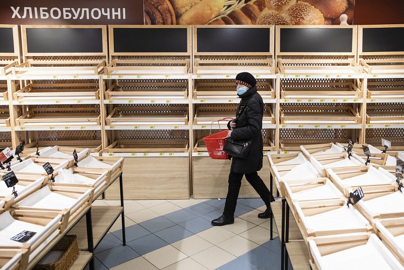 Una mujer ucraniana camina por el pasillo de una tienda que está casi vacía, en Kiev. 