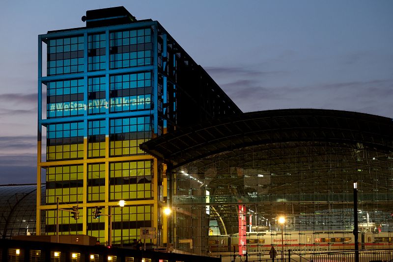 A view shows the facade of Berlin main train station illuminated in the colours of the Ukrainian flag