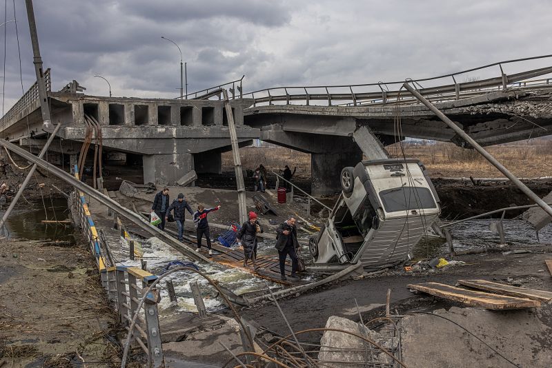 Residentes cruzan un puente destruido mientras huyen de la ciudad de Irpin, en la región de Kiev, Ucrania, el 7 de marzo de 2022.