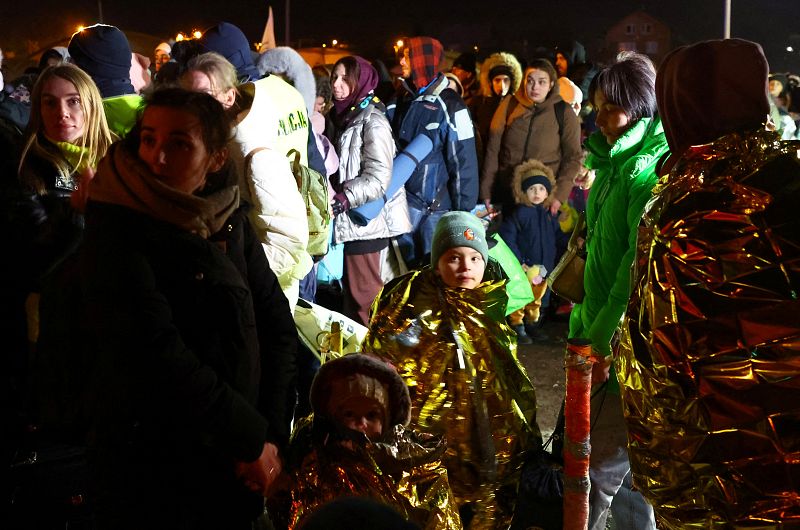 Personas que huyen de la invasión rusa de Ucrania esperan un autobús tras cruzar la frontera de Ucrania a Polonia, en el puesto de control fronterizo de Medyka, Polonia, el 7 de marzo de 2022.