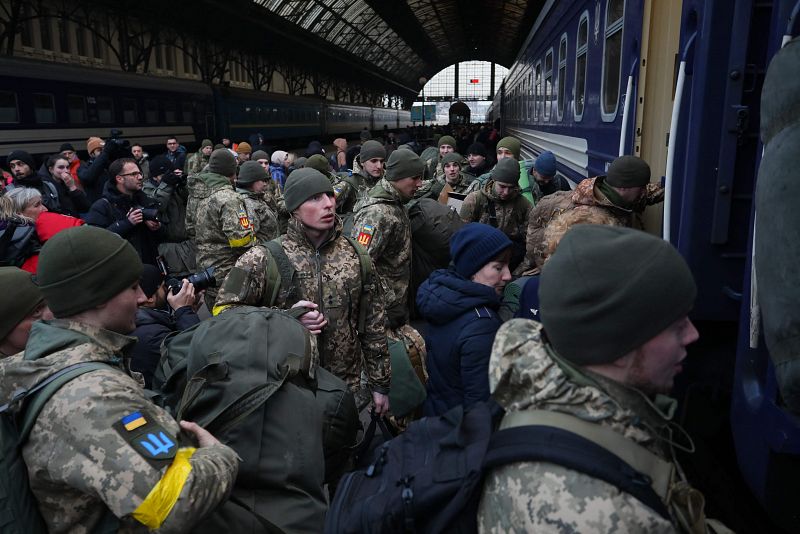 Militares ucranianos tratan de montar en un tren para dirigirse a Kiev