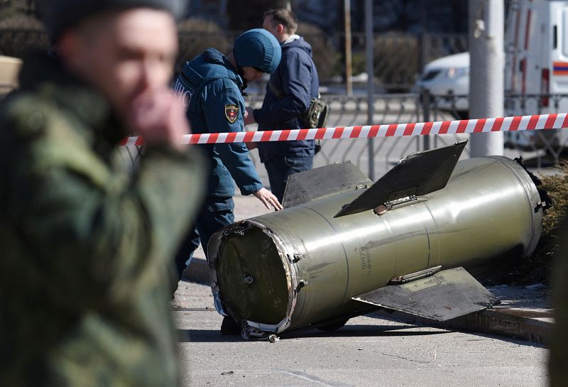 Un miembro de Emergencias de la región separatista de Donetsk inspecciona los restos de un misil que ha caído en una calle de la ciudad, controlada por los separatistas prorrusos